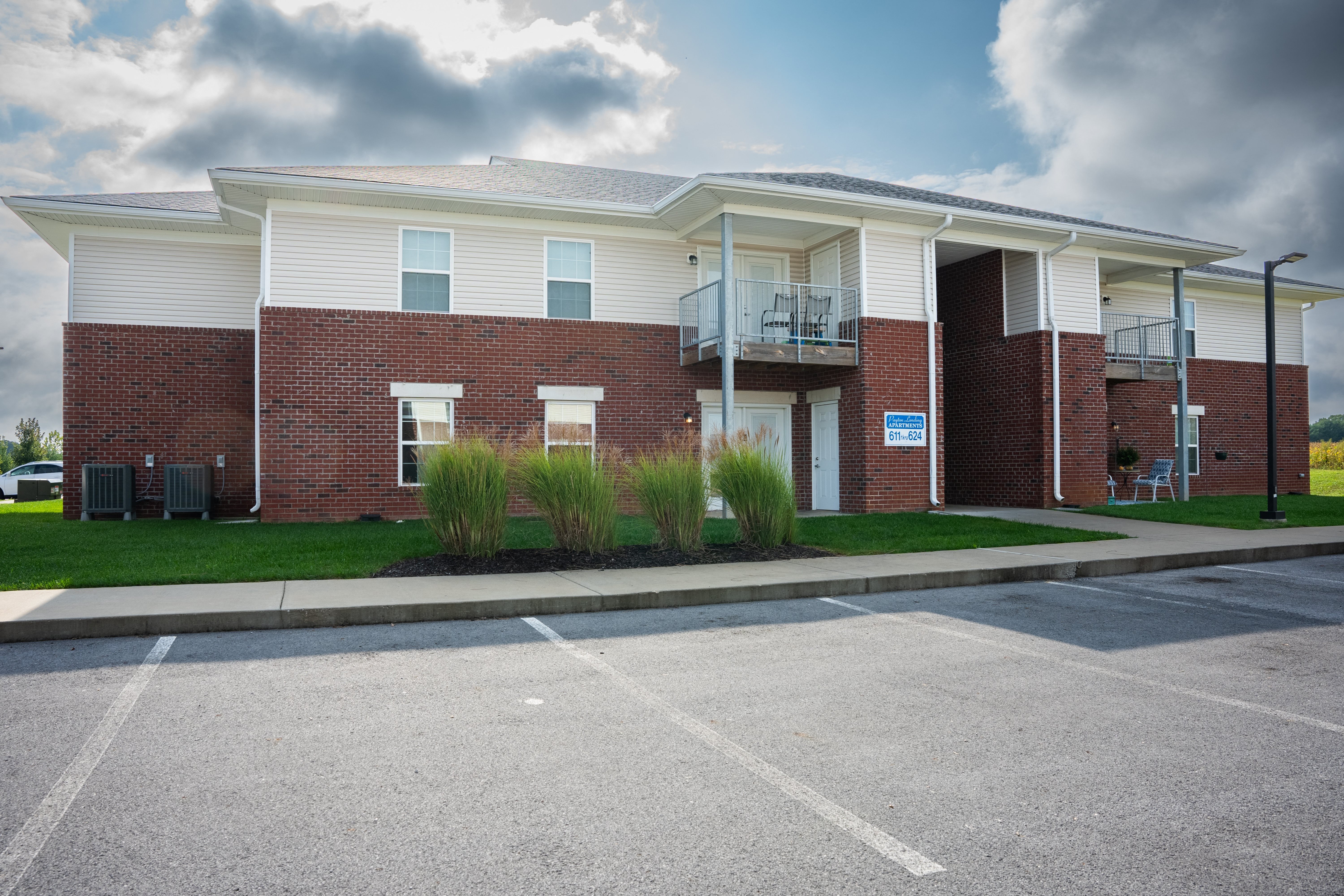 the front of a brick building with a parking lot